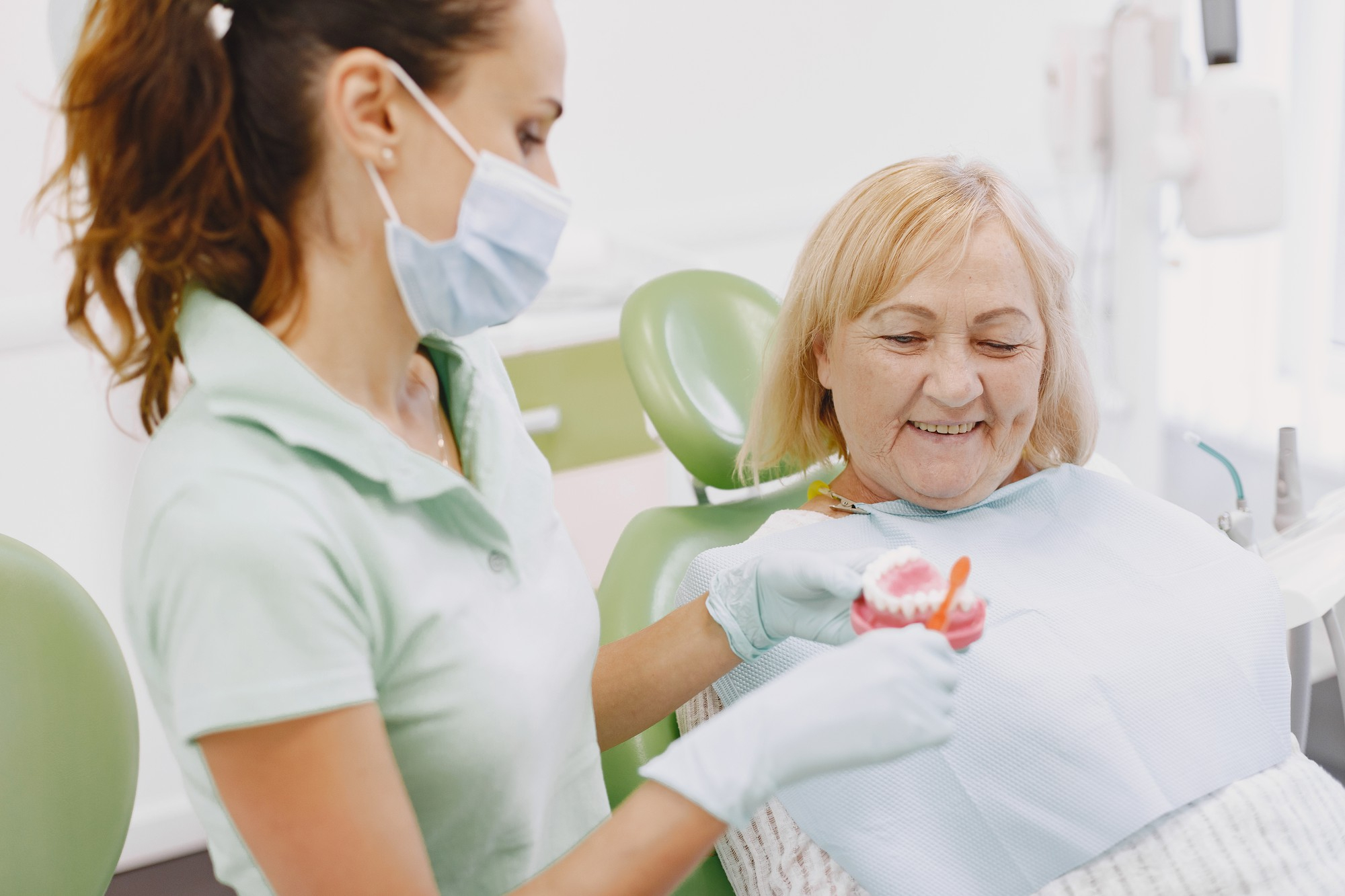 An elderly dental patient being shown a set of dentures just before the procedure